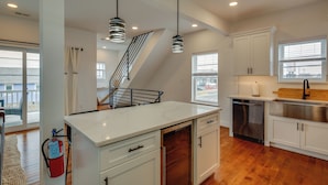 A modern kitchen with white cabinets, stainless steel appliances, and pendant lighting. - The Kraken Wildwood Townhome: 1/2 Mi to Beach! (Wildwood)
