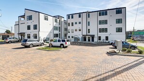 Un edificio residencial de varios pisos con un estacionamiento.