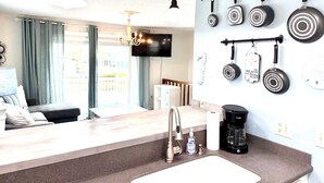 A modern kitchen with a built-in stove, a coffee maker, and a sink. - Island Cottage 1 Bedroom Townhouse by RedAwning (Navarre)