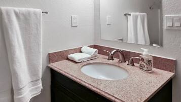 A bathroom with a white sink, a mirror, and a towel rack.
