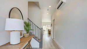 A hallway with a wooden bench, a white lamp, and a potted plant. - St George Home w/ Patio - 8 Mi to Snow Canyon! (St. George)