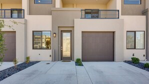 A modern two-story house with a garage, a balcony, and a small garden area. - St George Home w/ Patio - 8 Mi to Snow Canyon! (St. George)