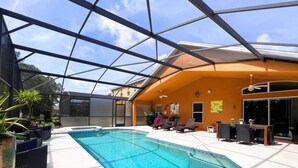 A swimming pool with a glass ceiling, surrounded by lounge chairs and a dining area. - Great Privacy By Pool- Pool Home With Game Room 4 Bedroom Home by RedAwning (Davenport)