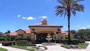 A building with a central fountain, palm trees, and a clear blue sky. - Great Privacy By Pool- Pool Home With Game Room 4 Bedroom Home by RedAwning (Davenport)