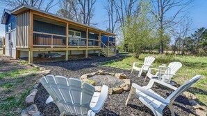 Eine Holzhütte mit einer Terrasse und einer Sitzgelegenheit im Freien.