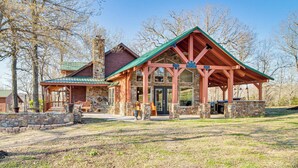 A lodge with a stone facade, wooden exterior, and a covered patio area. - Expansive Mountain Home Rental w/ Yard & Fire Pit! (Mountain Home)