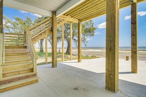 A wooden staircase leading to a covered outdoor area with a view of the beach and ocean. - Long Beach Home w/ Views & On-site Beach Access! (Long Beach)
