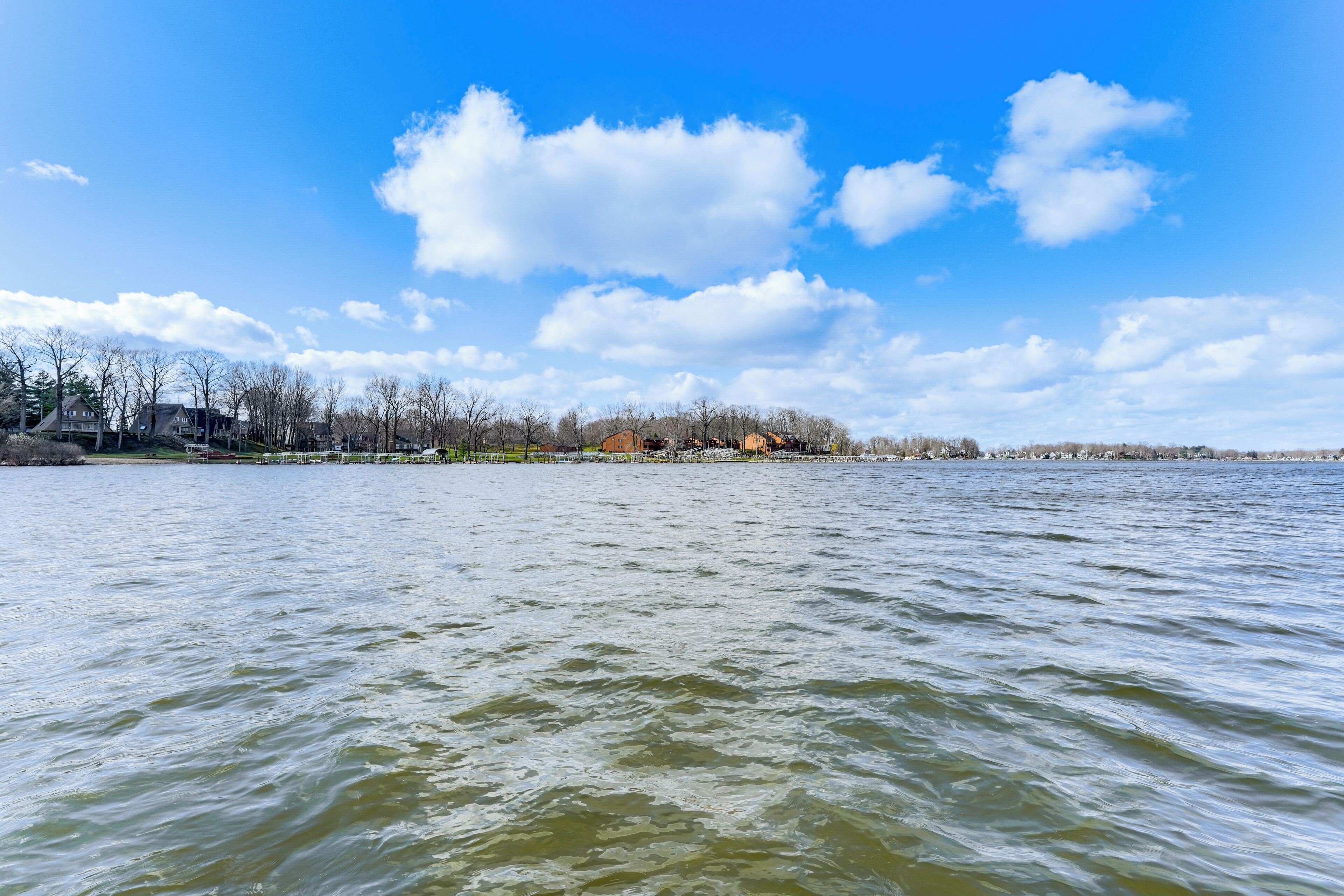 A waterfront view with a clear sky and calm water.