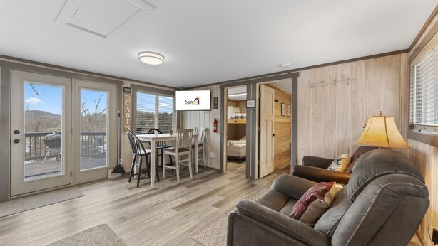 A spacious living area with a dining table, a sofa, and a TV. - Gone Fishin 2 Bedroom Cabin by RedAwning (Kimberling City)