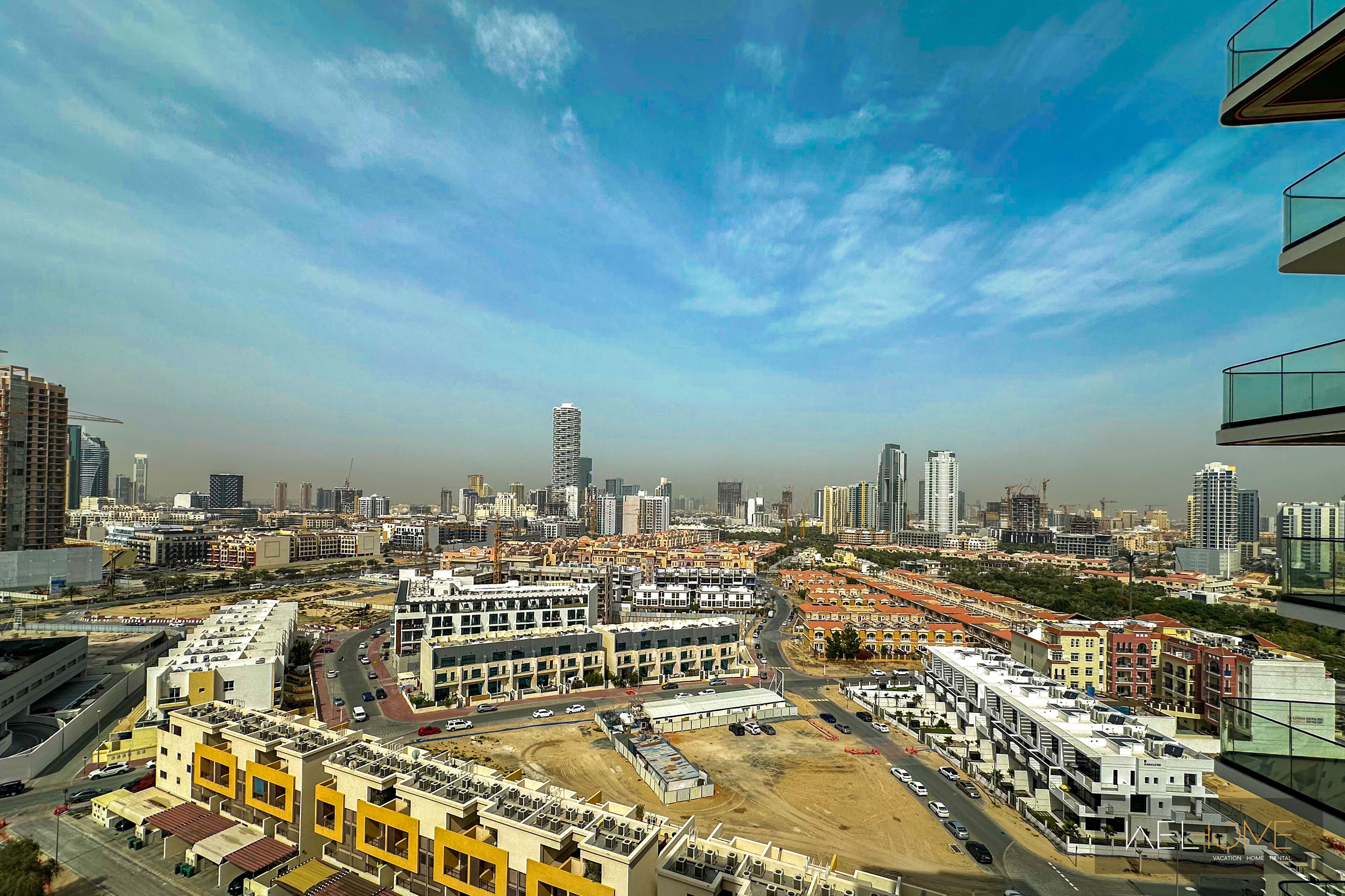 A cityscape with high-rise buildings, a construction site, and a clear sky.