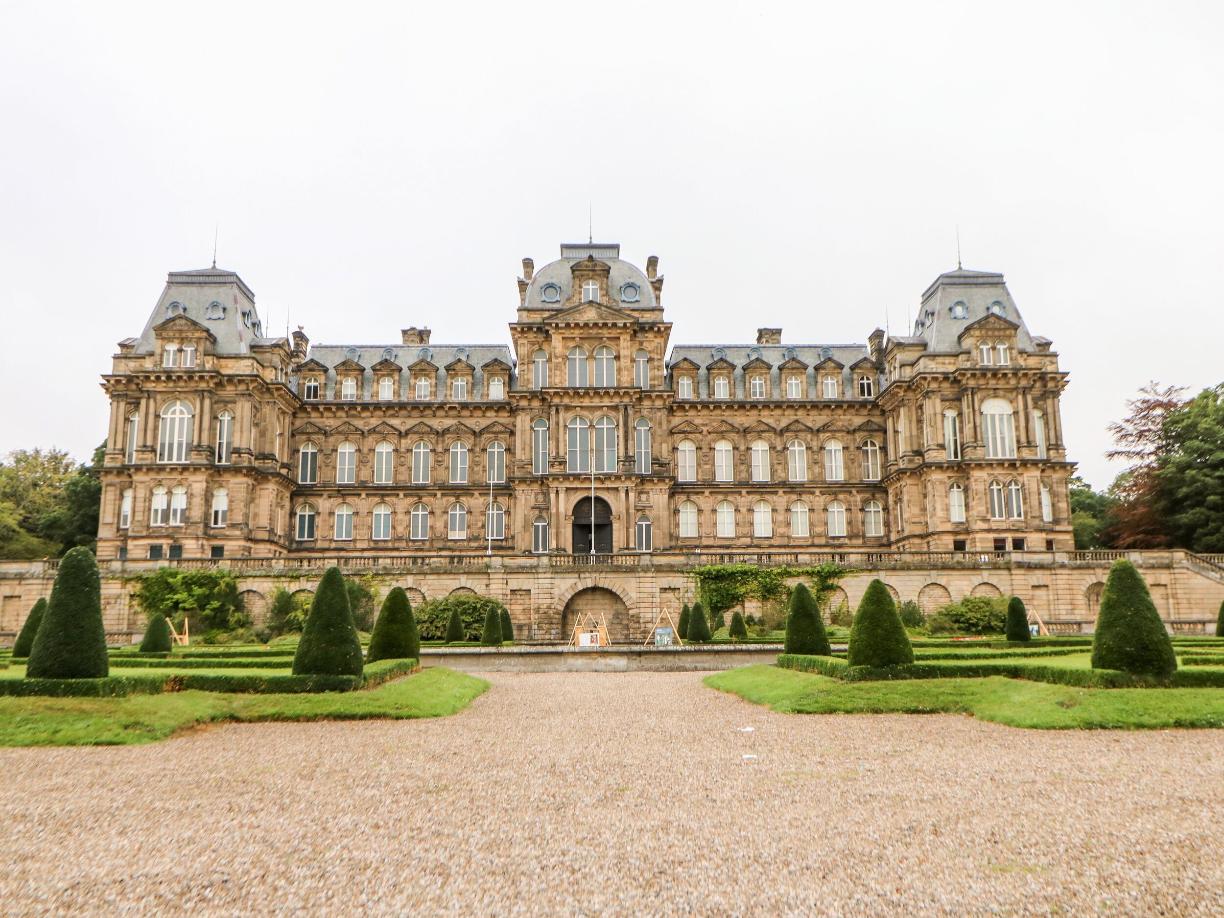 A large, historic building with symmetrical architecture, featuring multiple windows and a central entrance.