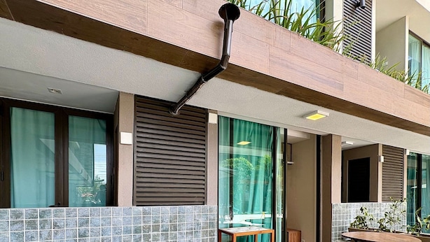 A modern outdoor pool with tiled edges, a wooden deck, and a seating area with a table and chairs. - Sunny Hall Flats  (Ipojuca)