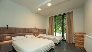 A modern bedroom with two beds, a large window with curtains, and a wooden cabinet. - Villa Ipanema (Telavi)
