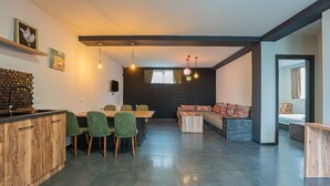 A modern interior with a dining area, a sofa, and a kitchen. - Villa Ipanema (Telavi)