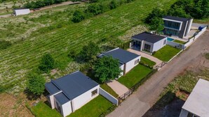 A modern residential area with several detached houses, each featuring a distinct architectural style with flat roofs and large windows. - Villa Ipanema (Telavi)