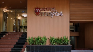 A hotel entrance with a sign reading "HOTEL MAYA 4" and a staircase leading inside.