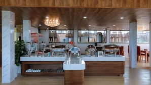 A buffet area with a marble counter, stainless steel appliances, and wooden accents.