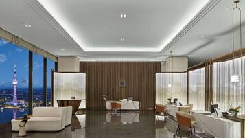 En modern hotellobby med ett stort panoramafönster, en receptionsdisk och en sittgrupp.