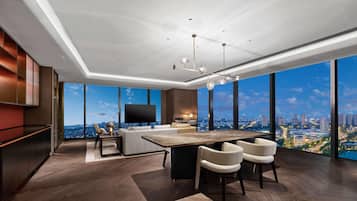 A modern living room with a large city view, a flat-screen TV, and a dining area with a wooden table and chairs.