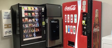 A vending machine area with a soap and bleach dispenser, an ice dispenser, and a Coca-Cola vending machine.