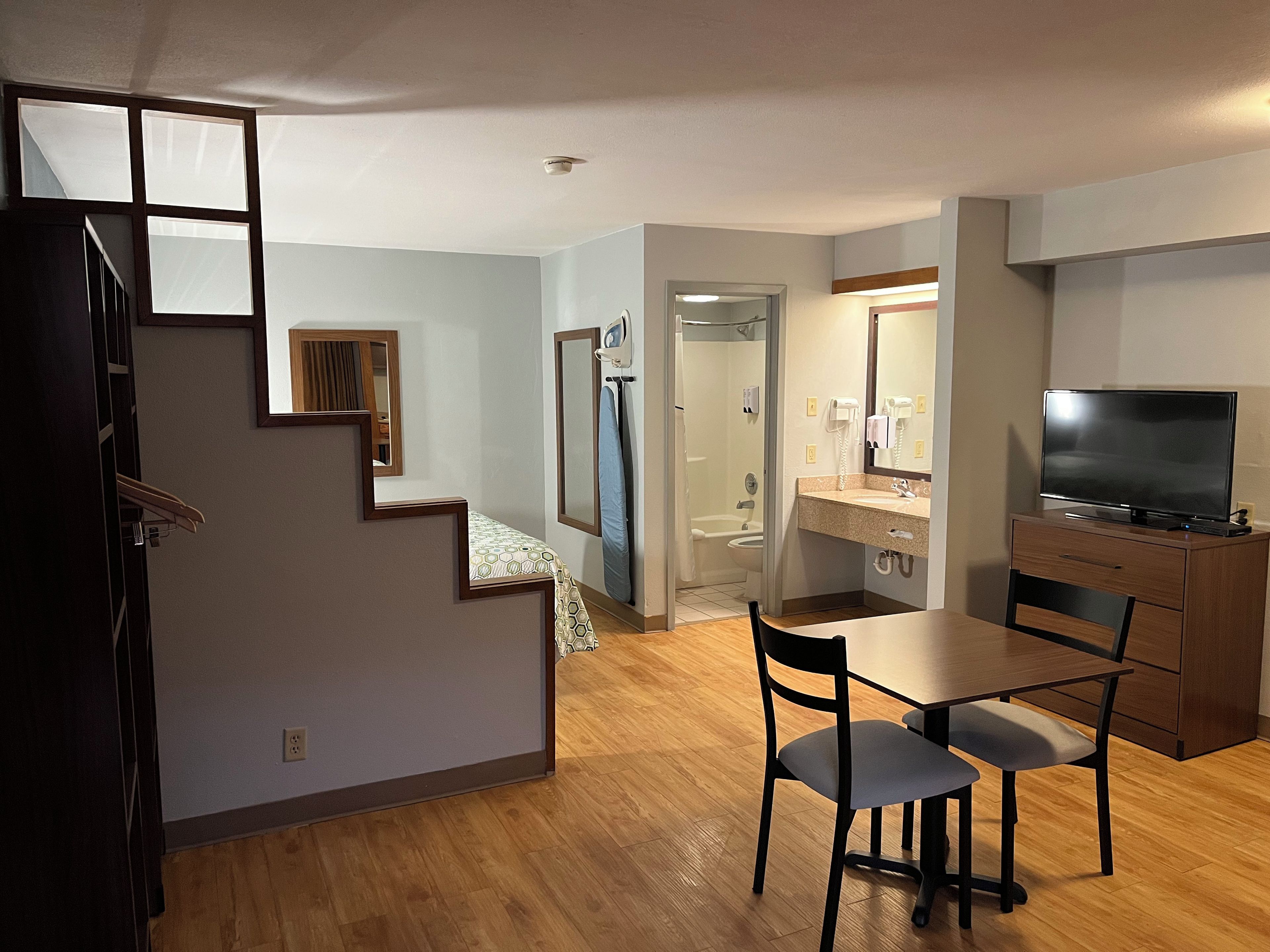 Un appartement moderne comprenant un coin repas, une cuisine et une salle de bain avec douche.