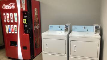 A vending machine with various drink options and a Whirlpool brand washing machine.
