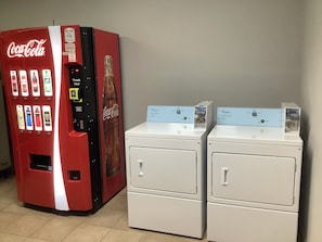 A vending machine with various drink options and a Whirlpool brand washing machine.