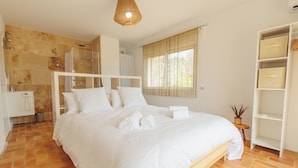A spacious bedroom with a large bed, a shower area, and a wardrobe. - Grande Maison Familiale Avec Piscine Dans Quartier Résidentiel Calme (Langlade)