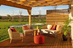 An outdoor patio with wicker furniture, a wooden table, and a potted plant. - Quinta Do Paral (Vidigueira)