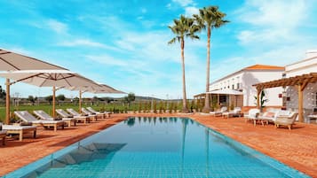 Utomhuspool, parasoller och solstolar