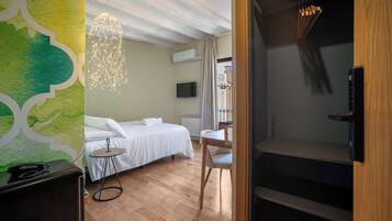 Una camera d'albergo con un letto, una scrivania, una sedia e una televisione.
