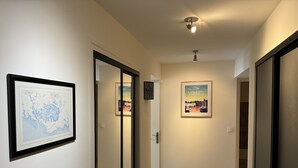 A hallway with framed artwork, a map, and a poster on the wall. - Flat for 4 in the centre of Sarzeau (Sarzeau)