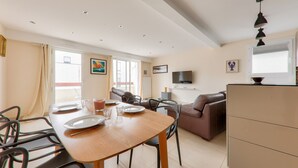 A modern living room with a dining area, a sofa, and a flat-screen TV. - Flat for 4 in the centre of Sarzeau (Sarzeau)