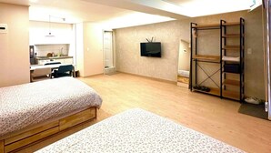 A spacious room with two beds, a TV mounted on the wall, and a built-in shelf unit. - R Guesthouse Jongmyo (Seoul)