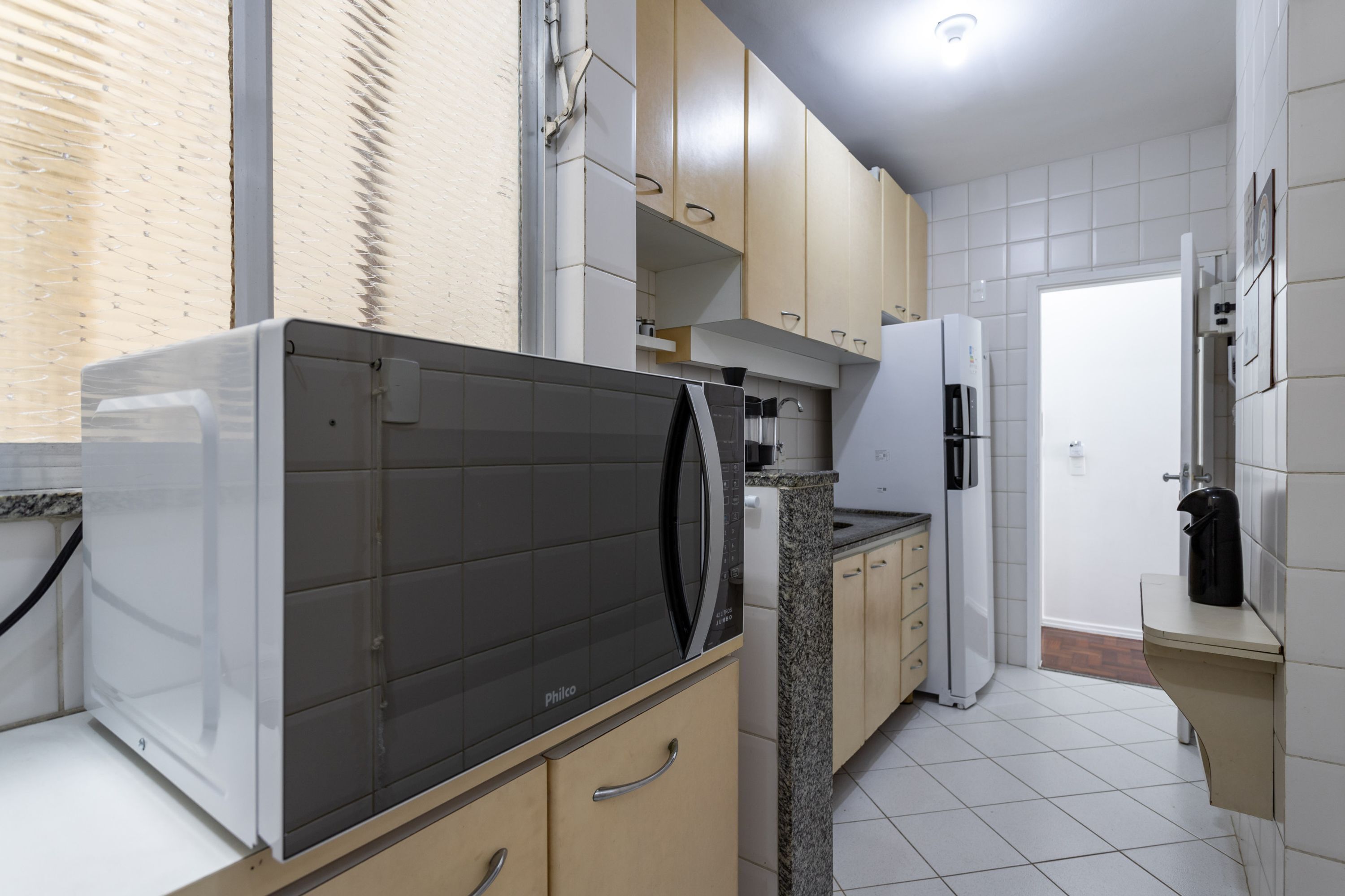 A modern kitchen with a dishwasher, refrigerator, and granite countertop.
