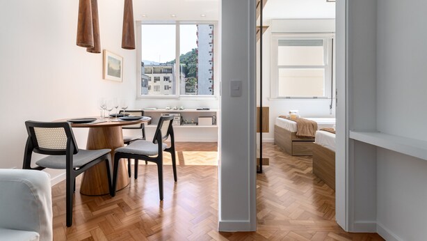 A modern interior with a dining area, wooden flooring, and a view of buildings outside. - 5 Minutes From the Beach and a View of Christ Br904 (Rio de Janeiro)