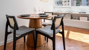 A dining area with a round wooden table, four chairs, and hanging pendant lights. - 5 Minutes From the Beach and a View of Christ Br904 (Rio de Janeiro)