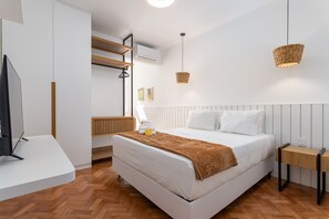A modern bedroom with a large bed, a bedside table, a TV, and a hanging light fixture. - 5 Minutes From the Beach and a View of Christ Br904 (Rio de Janeiro)