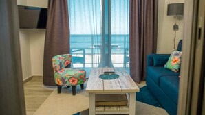 A room with a sofa, a chair, a table, and a TV. - BLUE VELVET (Nosy Be)
