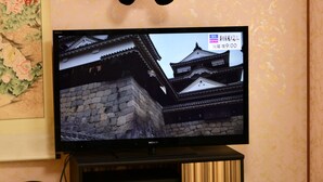 A television displaying a traditional building, a panda plush toy, and a map on the wall. - Himerakuen媛楽園　松山市中心部にある家族・グループ旅行の多人数が泊まれる最適な宿 (松山市)