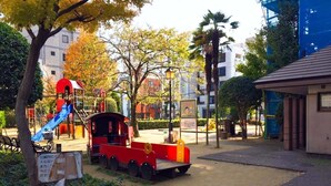 A playground with a red train, a slide, and a small building. - Himerakuen媛楽園　松山市中心部にある家族・グループ旅行の多人数が泊まれる最適な宿 (松山市)