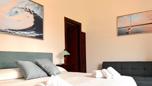 A hotel room with a bed, pillows, a nightstand, a lamp, and artwork on the walls. - B&B Hibiscus (Agropoli)
