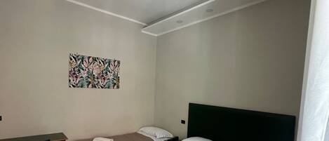 A hotel room with two beds, a desk, and a chair.