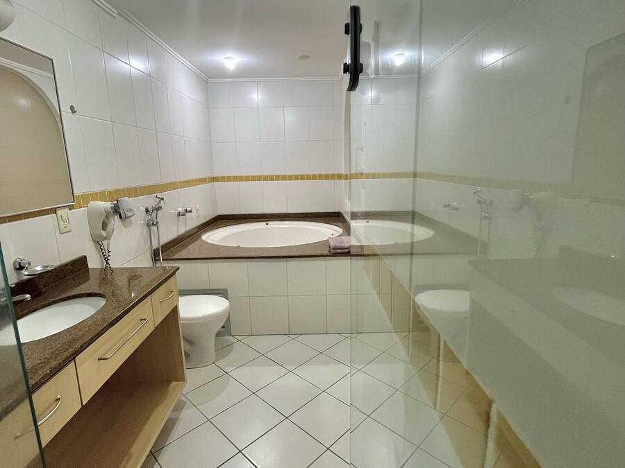 Un baño moderno con cabina de ducha de vidrio, tocador doble y un inodoro.