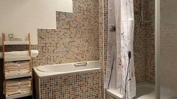 A bathroom with a tiled wall, a bathtub, a shower curtain, and a towel rack.
