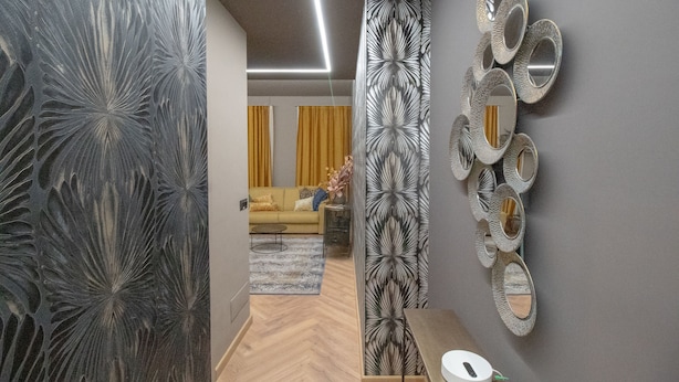A modern living room with a sofa, a coffee table, and a patterned wall divider. - Elegant and luxurious apartment for 6 people, in the heart of Turin (Torino)