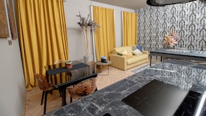 A modern living room with a sofa, a dining table, and yellow curtains. - Elegant and luxurious apartment for 6 people, in the heart of Turin (Torino)