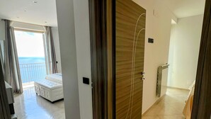 Habitación de hotel con una cama grande, vista al mar y diseño moderno.