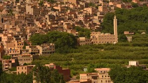 A densely packed hillside town with traditional architecture, including a prominent minaret. - Riad Dar Tagine (Asni)