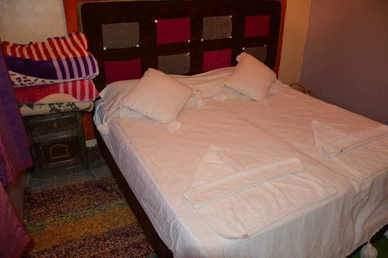 Una cama bien tendida con cabecera de diseño cuadriculado.